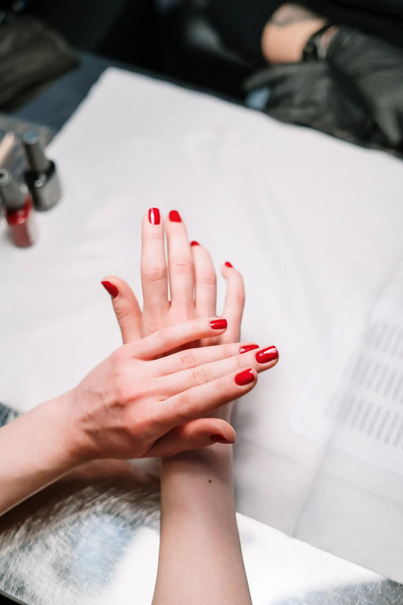 Mani con smalto rosso durante una manicure